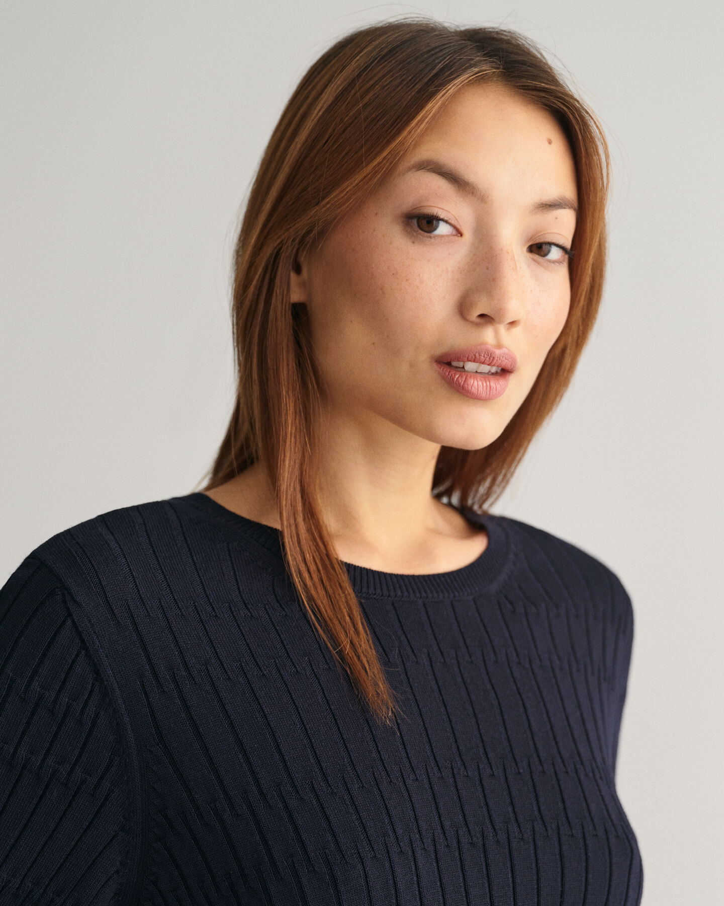 Lyhythihainen kohopintainen neulepusero, jossa pyöreä pääntie