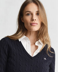 Joustava puuvillapalmikkoneule, jossa v‑pääntie