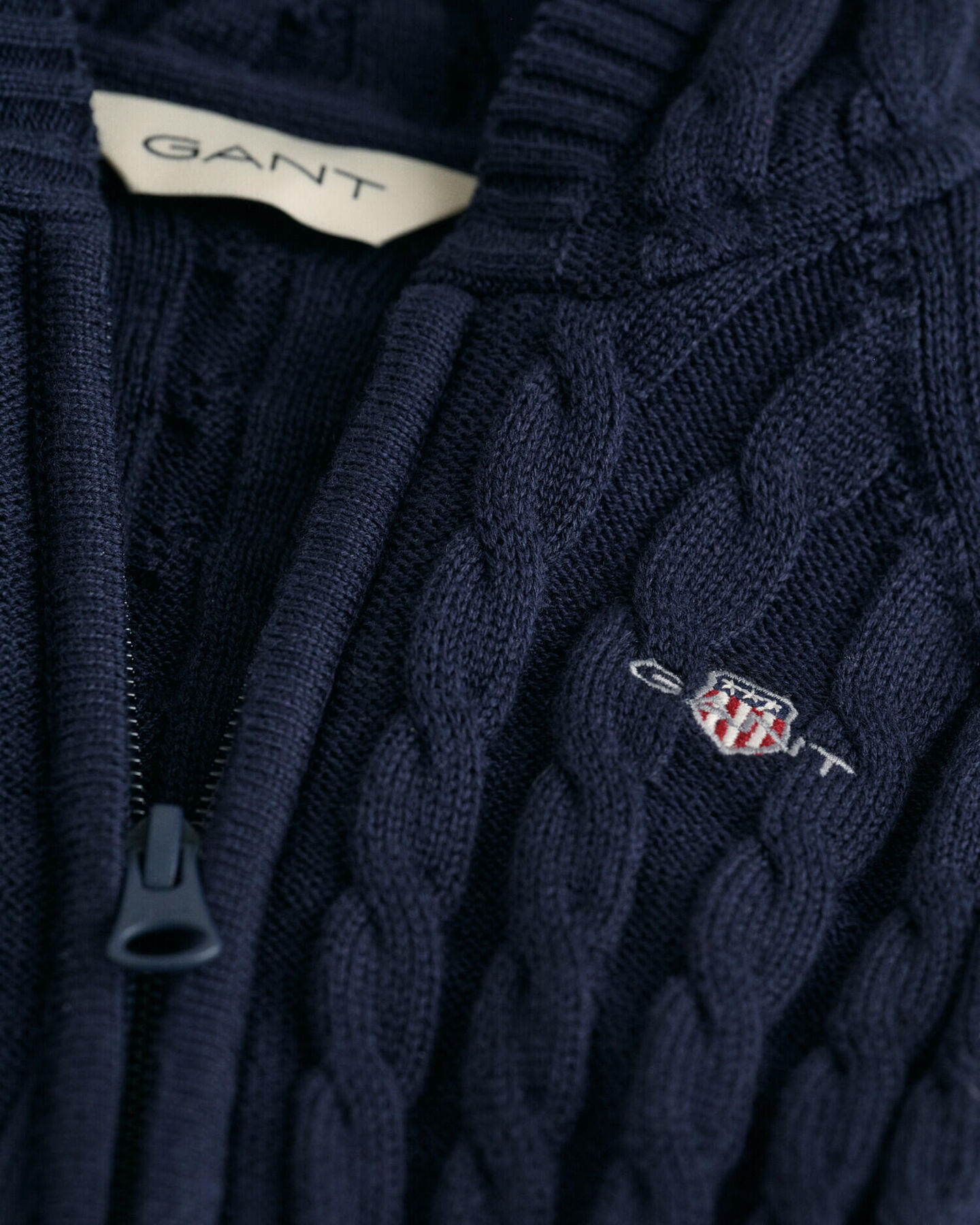 Baby-malliston puuvillainen Shield-palmikkoneulehaalari