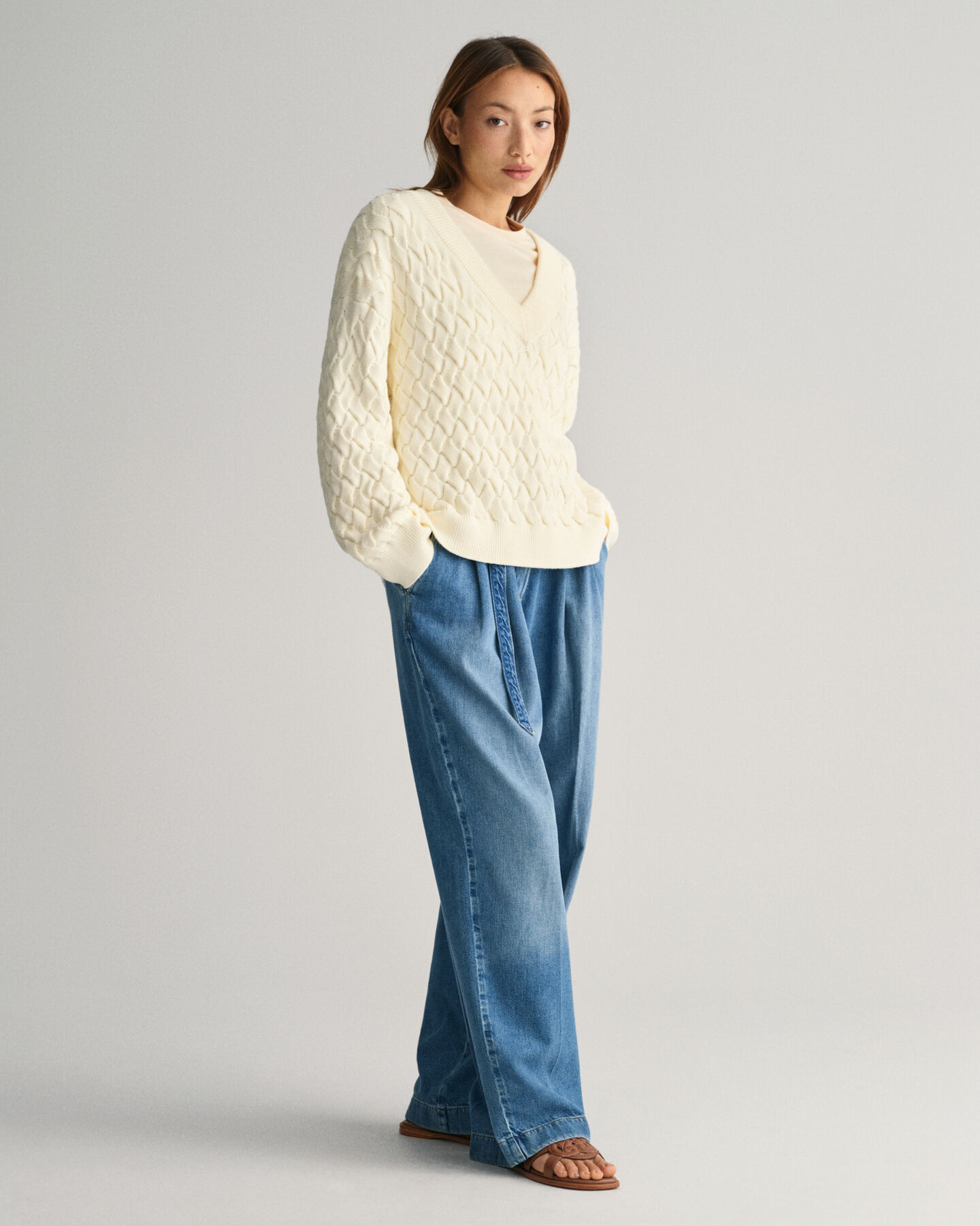 Kohopintainen puuvillaneulepusero, jossa v-p&auml;&auml;ntie