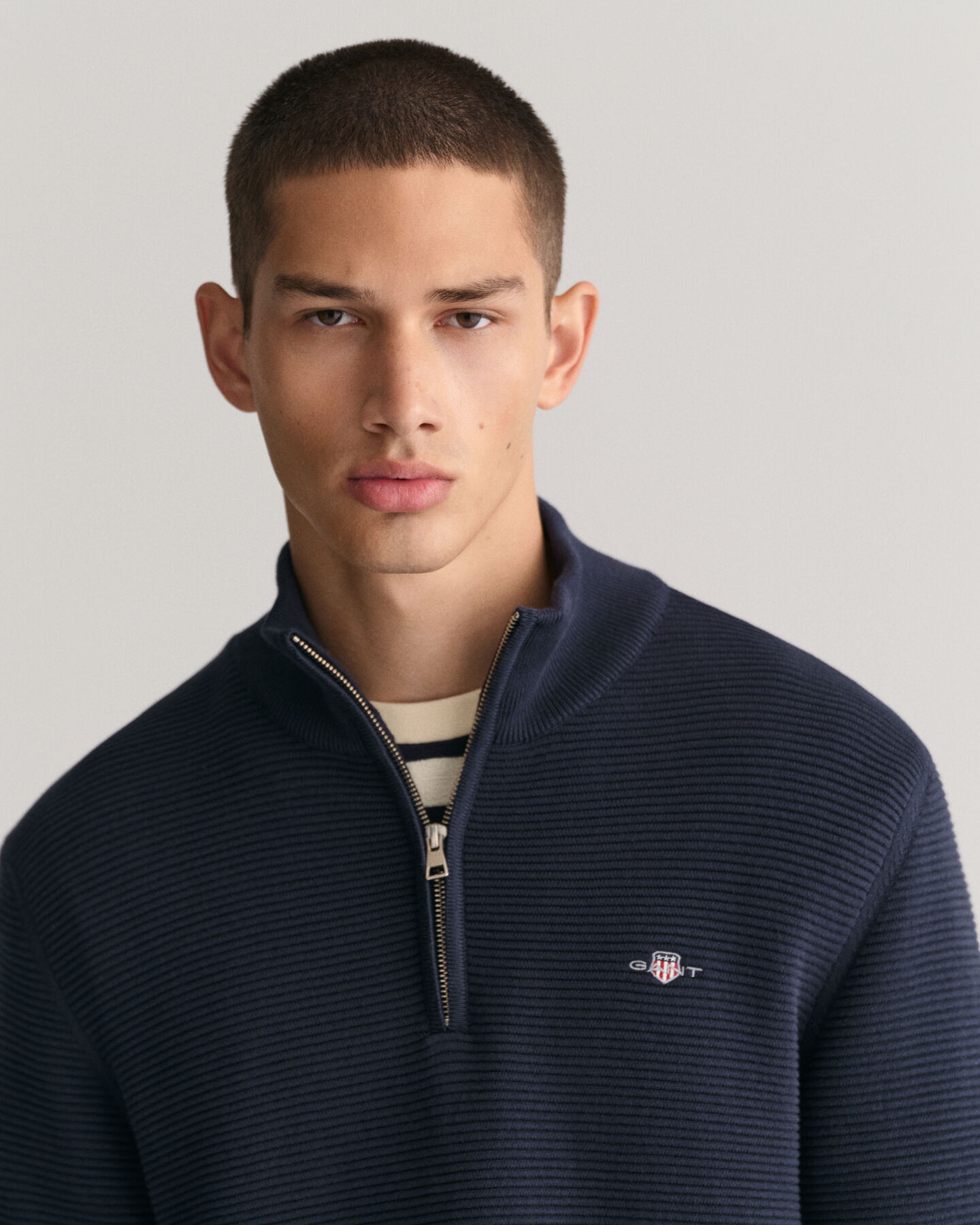 Kohopintainen puuvillaneulepusero, jossa vetoketjullinen p&auml;&auml;ntie