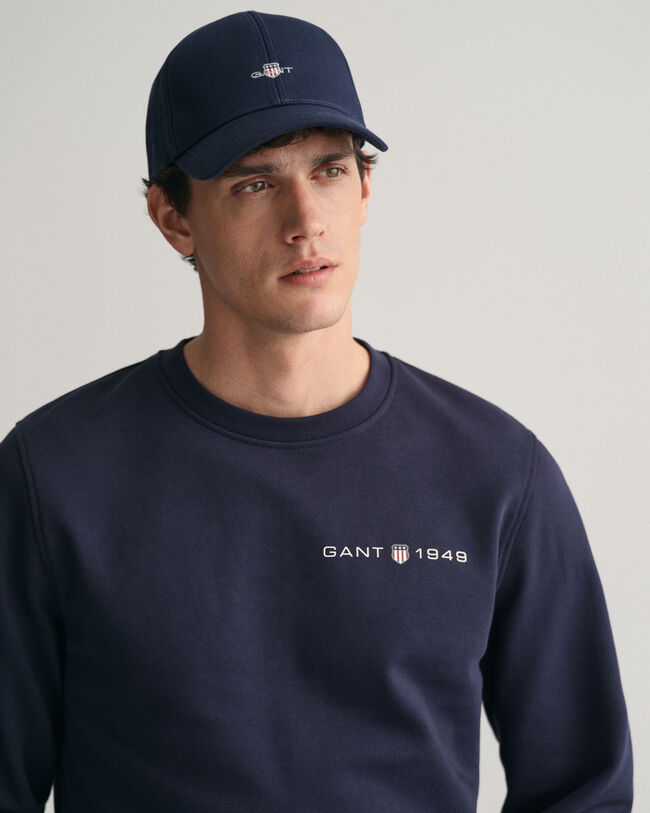 Py&ouml;re&auml;ll&auml; p&auml;&auml;ntiell&auml; ja painatuksella varustettu collegepaita