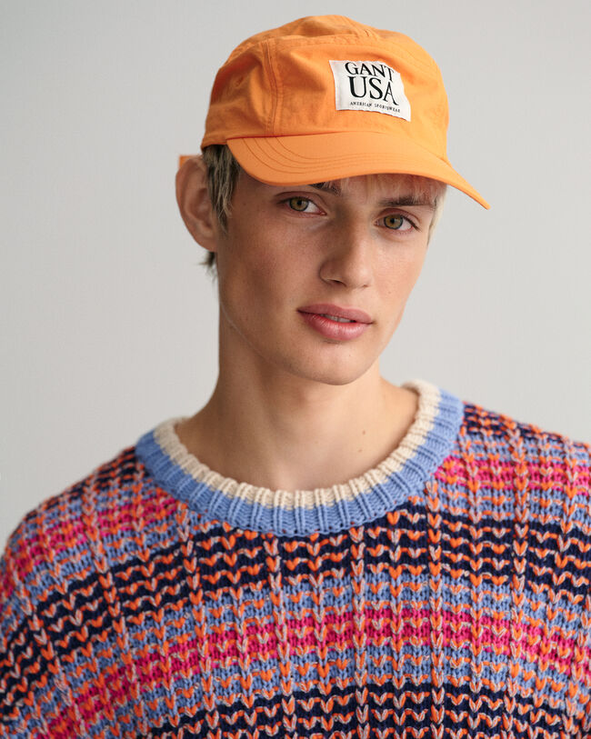 Kohopintainen monisävyinen neulepusero, jossa pyöreä pääntie