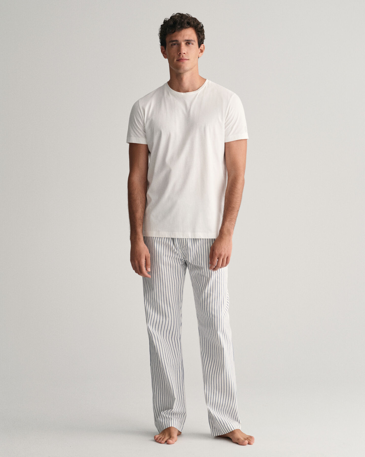 Raidalliset pyjamahousut ja t‑paita lahjapakkauksessa