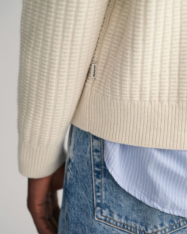 Kohopintainen neulepusero, jossa py&ouml;re&auml; p&auml;&auml;ntie