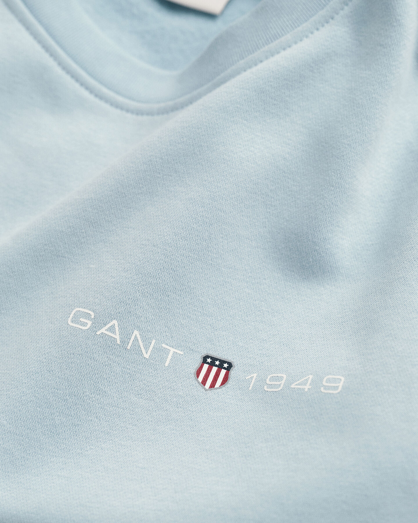 Py&ouml;re&auml;ll&auml; p&auml;&auml;ntiell&auml; ja painatuksella varustettu collegepaita