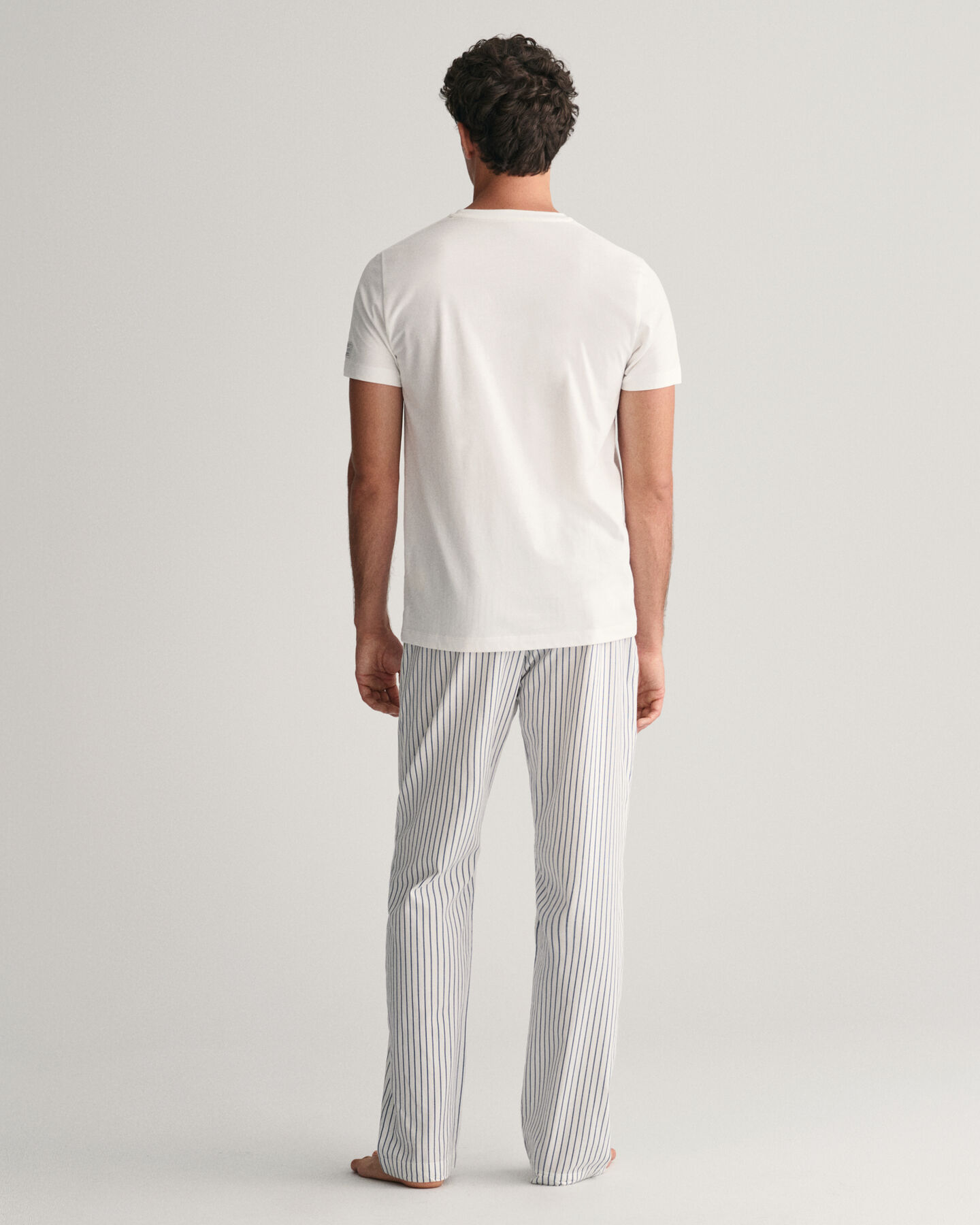 Raidalliset pyjamahousut ja t‑paita lahjapakkauksessa