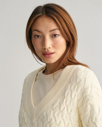 Kohopintainen puuvillaneulepusero, jossa v-p&auml;&auml;ntie