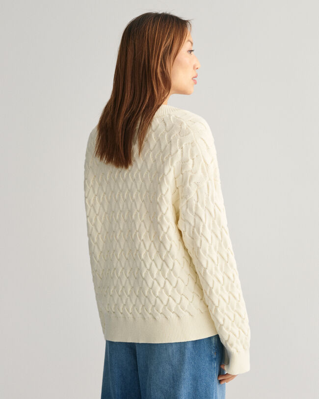 Kohopintainen puuvillaneulepusero, jossa v-p&auml;&auml;ntie