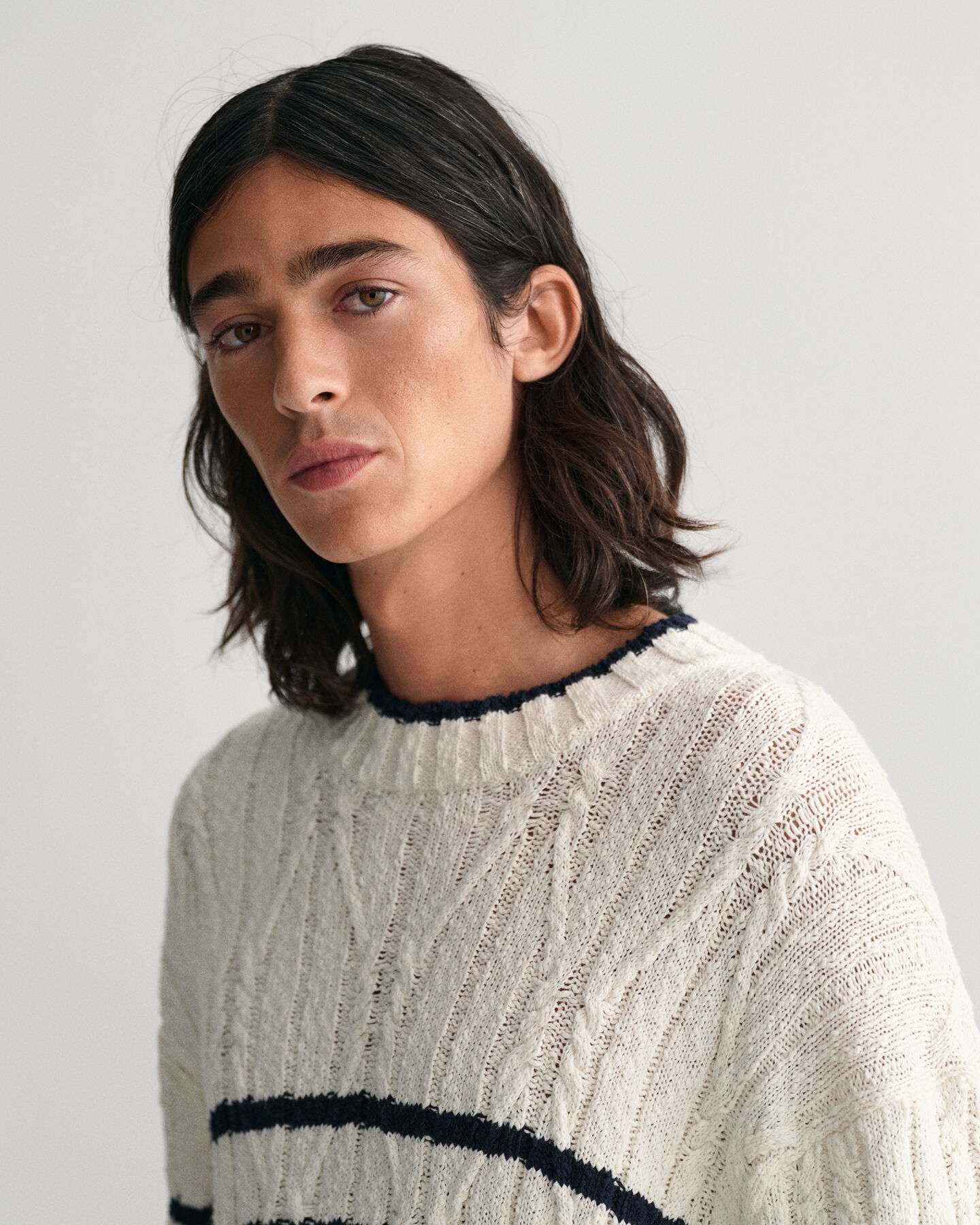 Raidallinen palmikkoneulepusero, jossa py&ouml;re&auml; p&auml;&auml;ntie