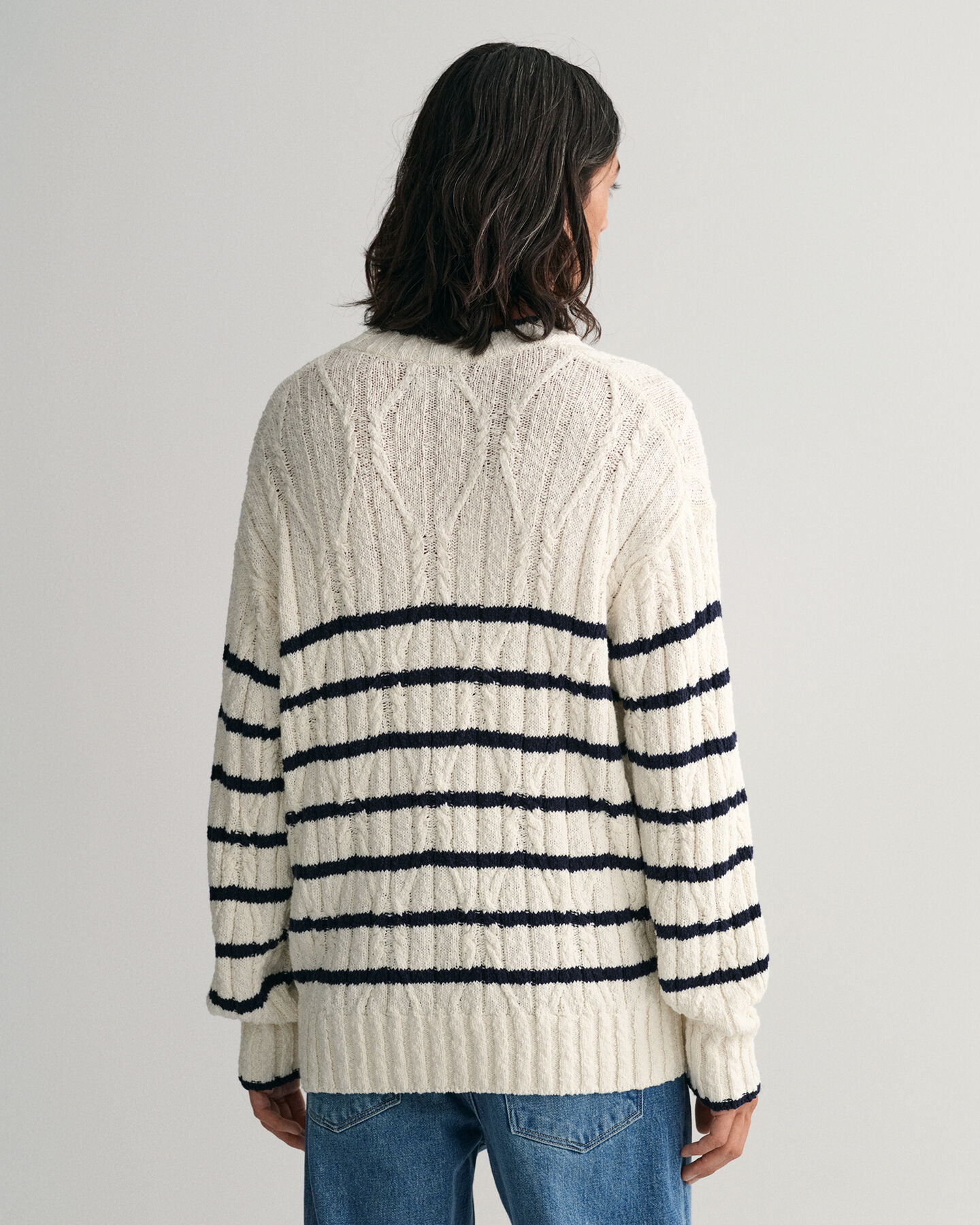 Raidallinen palmikkoneulepusero, jossa py&ouml;re&auml; p&auml;&auml;ntie