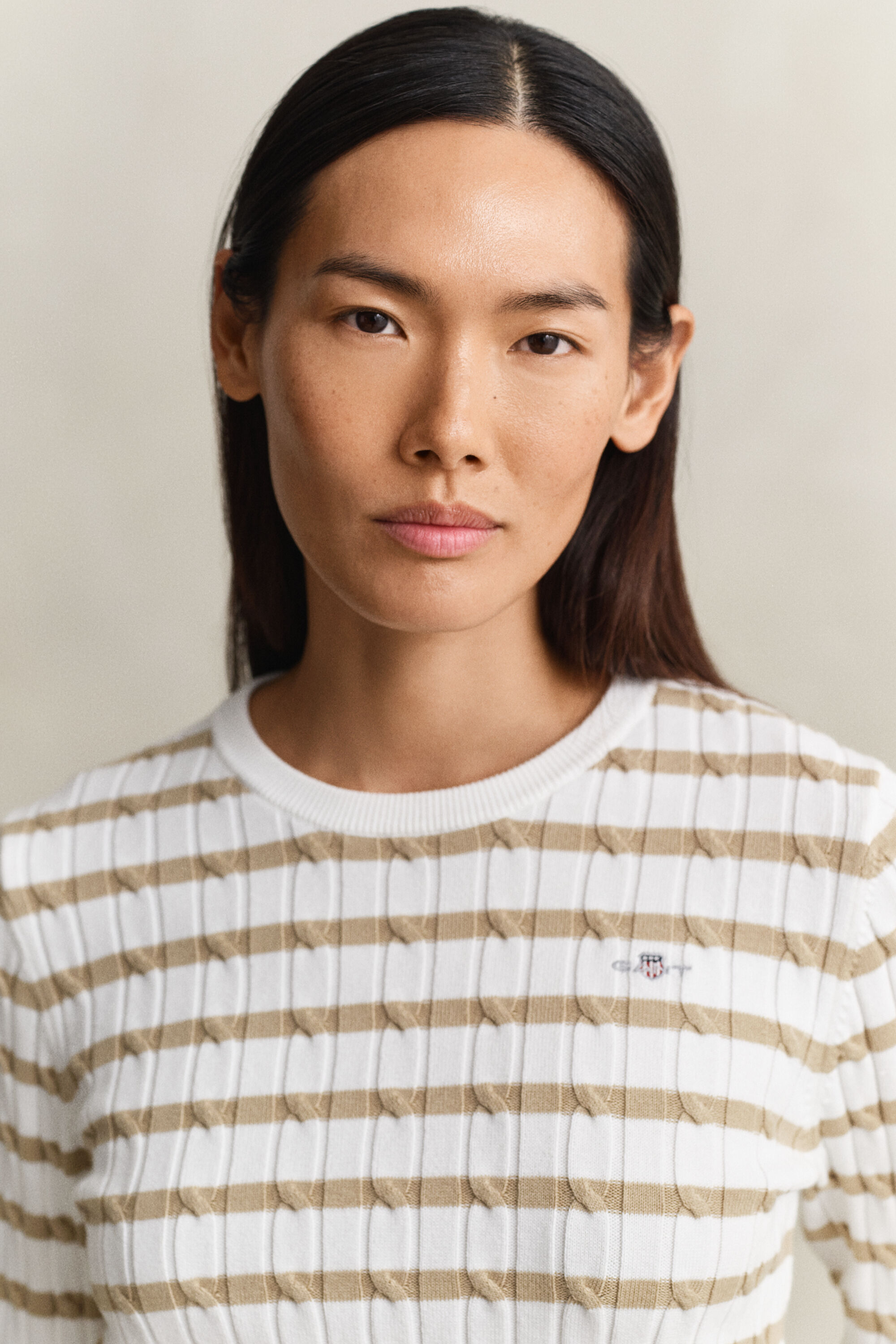 Raidallinen palmikkoneulepusero, jossa pyöreä pääntie