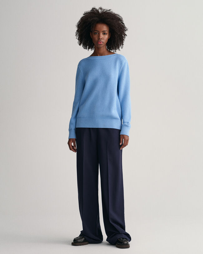 Kohopintainen puuvillaneulepusero, jossa venepääntie