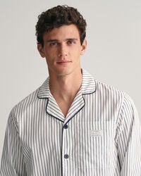 Raidalliset pyjamahousut ja ‑paita lahjapakkauksessa