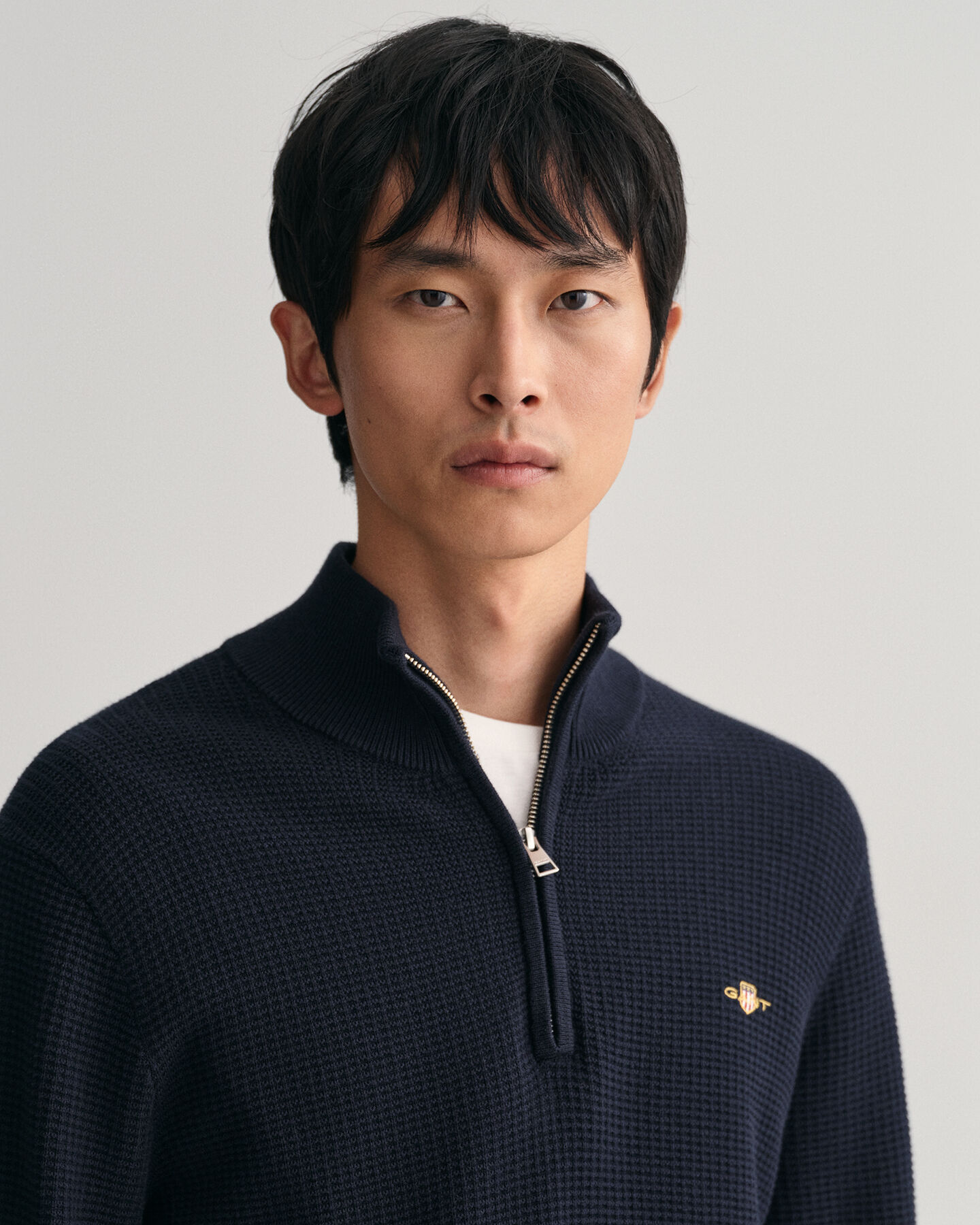 Kohopintainen puuvillaneulepusero, jossa vetoketjullinen pääntie