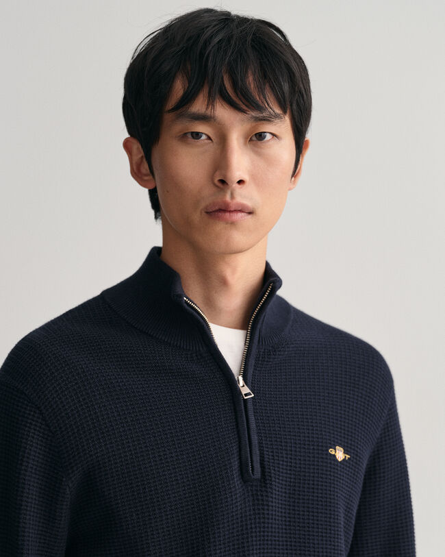 Kohopintainen puuvillaneulepusero, jossa vetoketjullinen pääntie